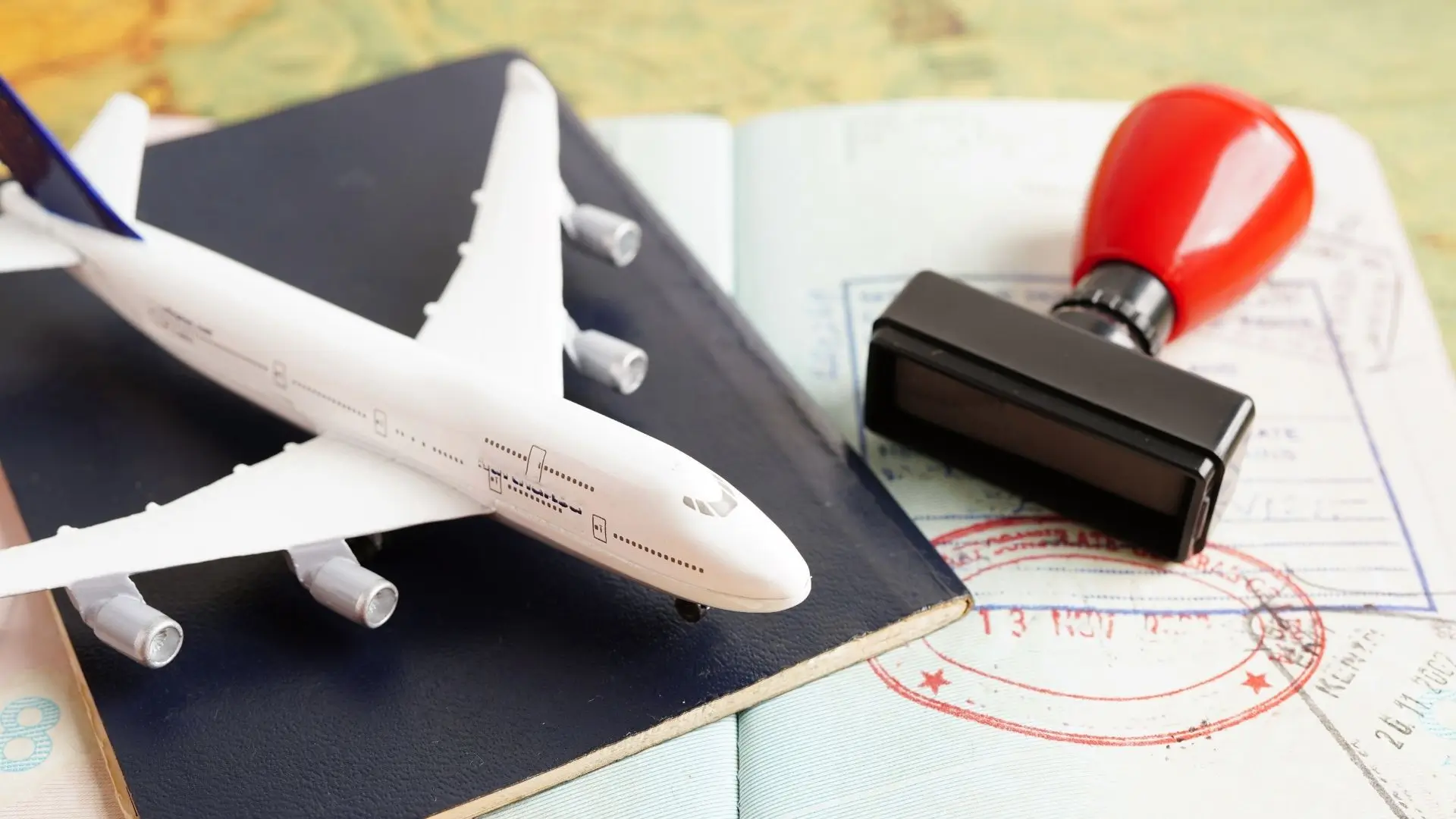 An airplane, a passport, and a stamp with an ink pad, symbolizing travel and international journeys.