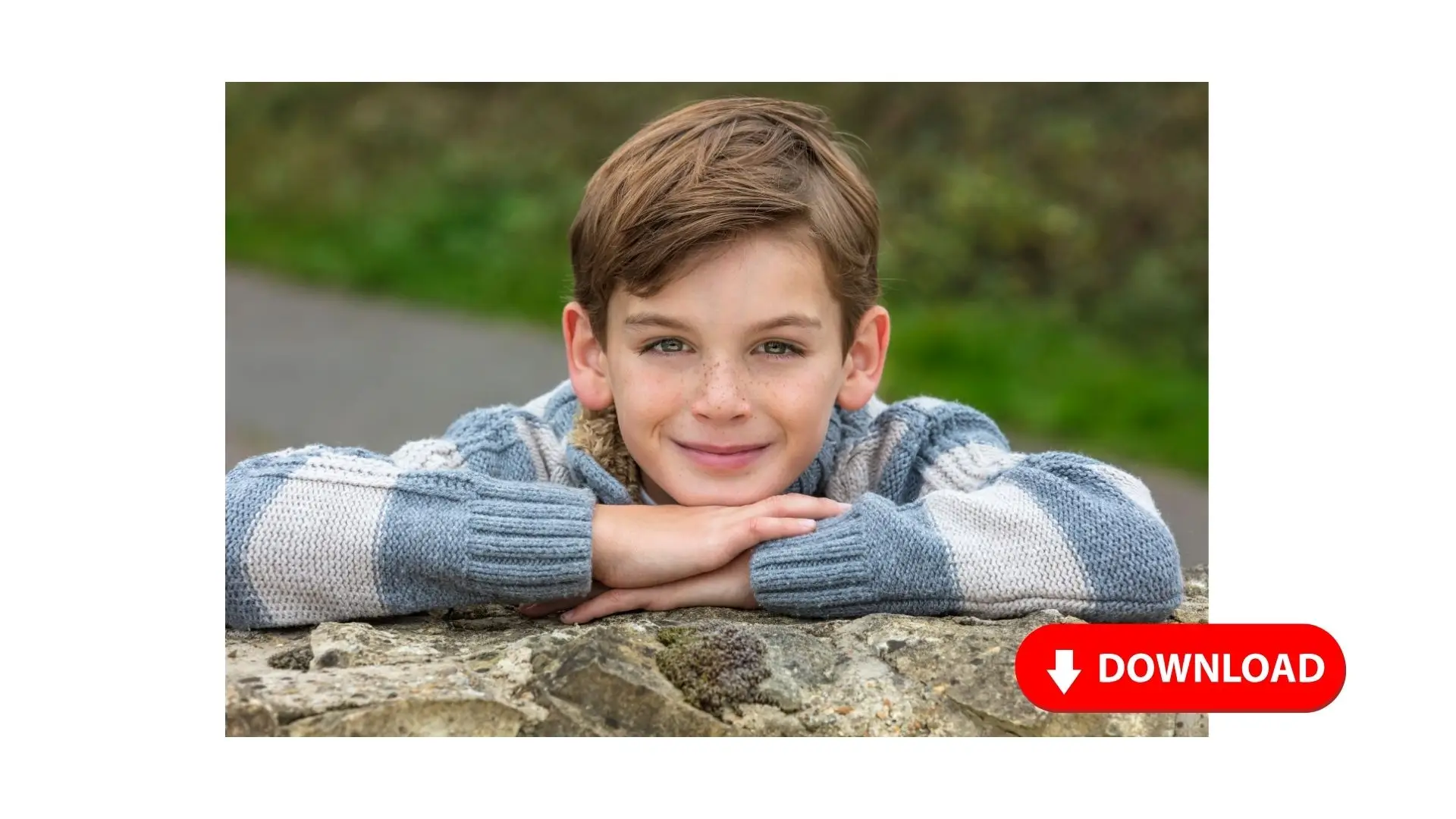 A boy leans against a rock, arms crossed over his chest, gazing thoughtfully into the distance.