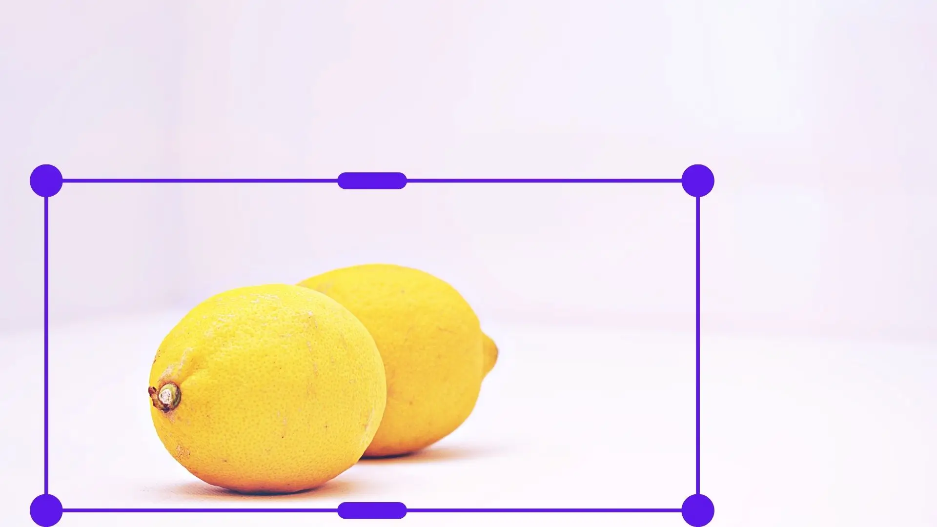 Two bright lemons displayed in a square frame, showcasing their vibrant yellow color and smooth texture.