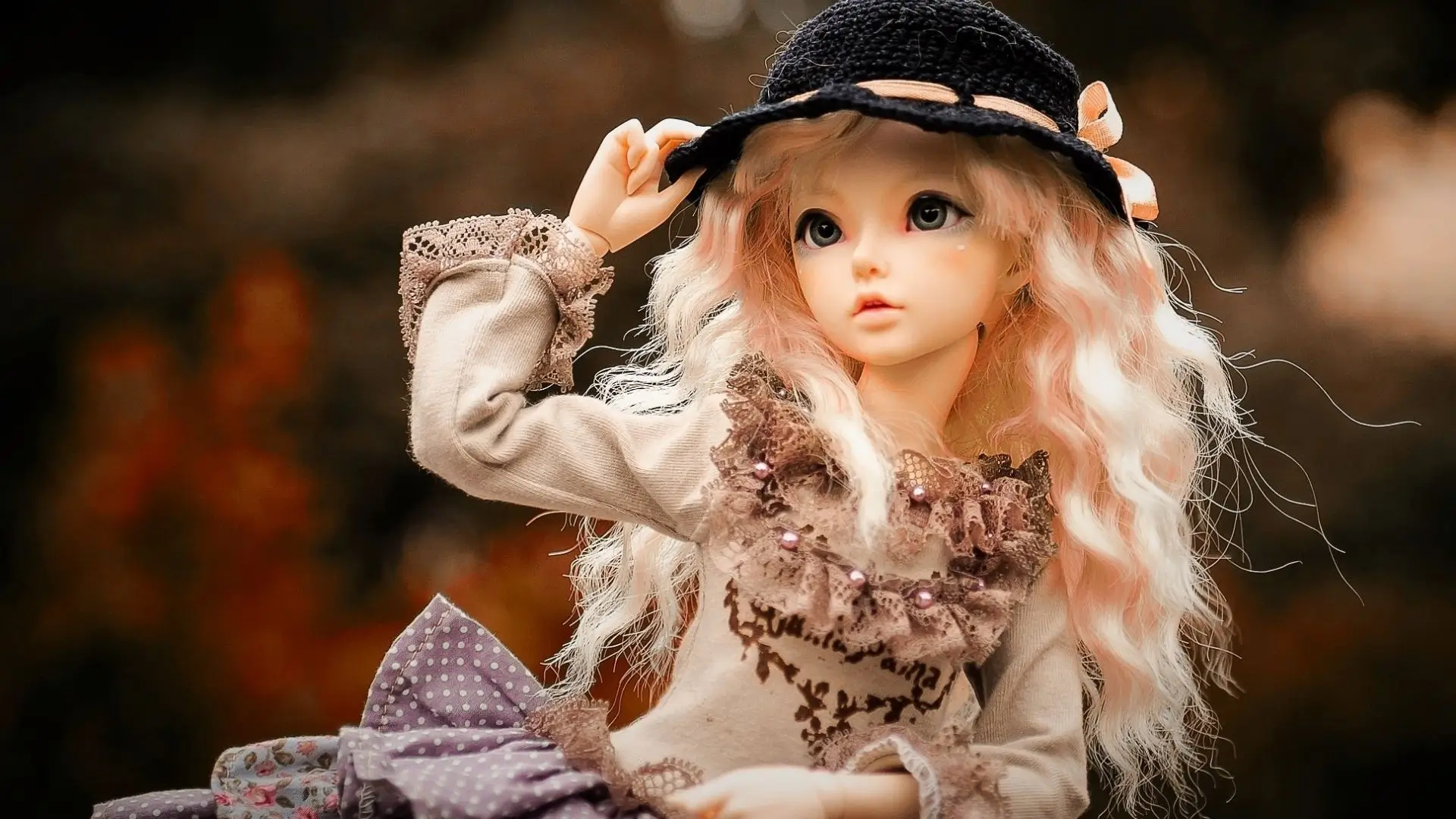 A doll with long hair adorned in a stylish hat, showcasing a charming and playful appearance.