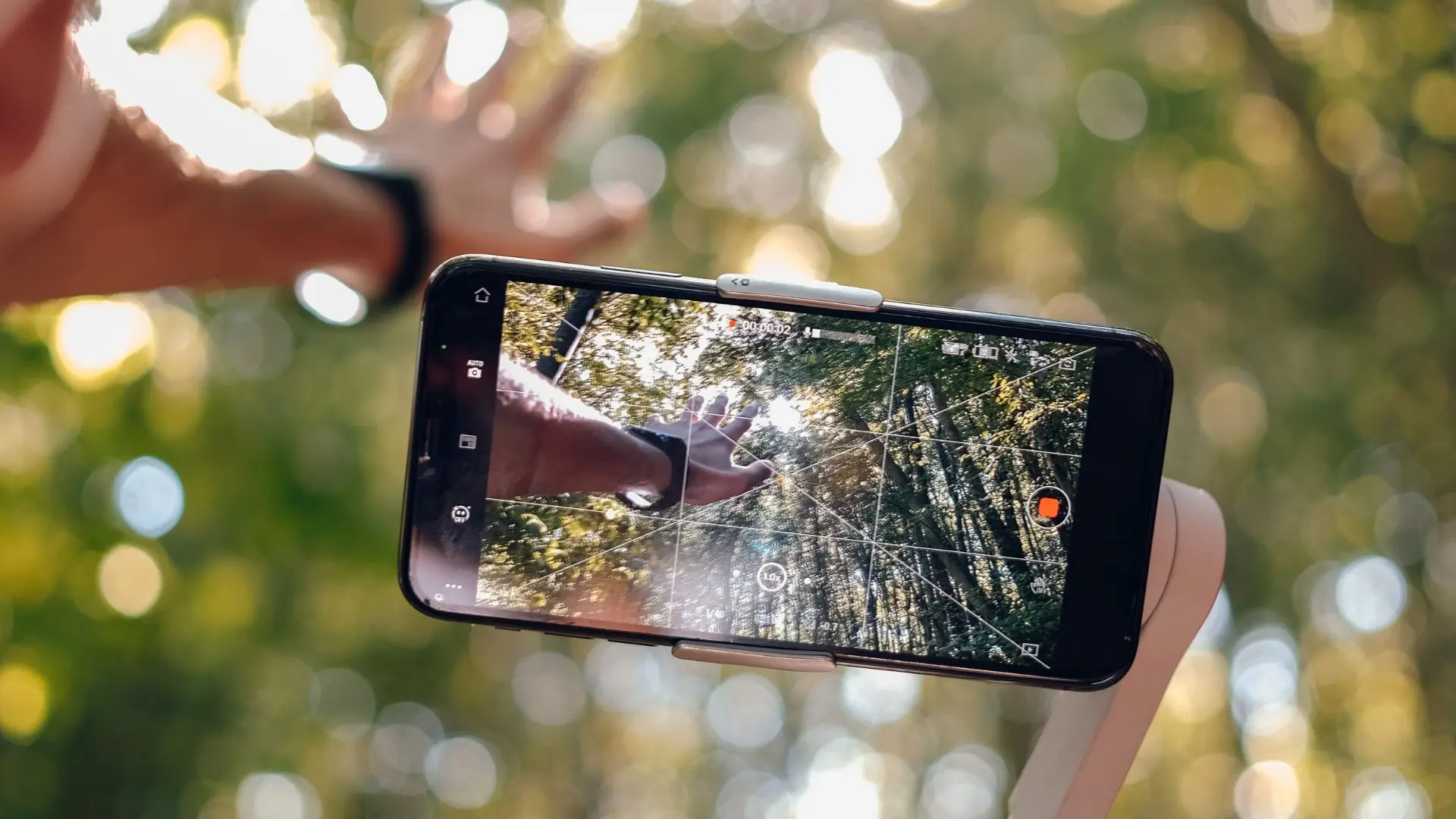 A person raises a smartphone with a camera, capturing a moment with a focused expression.