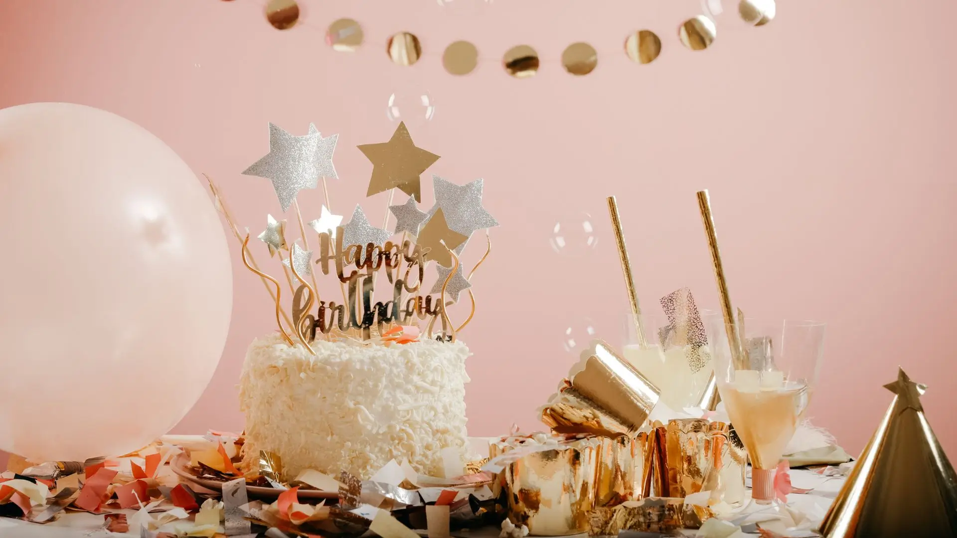 A festive birthday cake adorned with gold stars and colorful balloons, celebrating a special occasion.