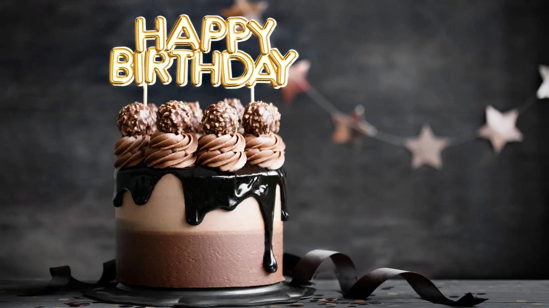 A chocolate cake adorned with candles and a cheerful birthday sign, celebrating a special occasion.