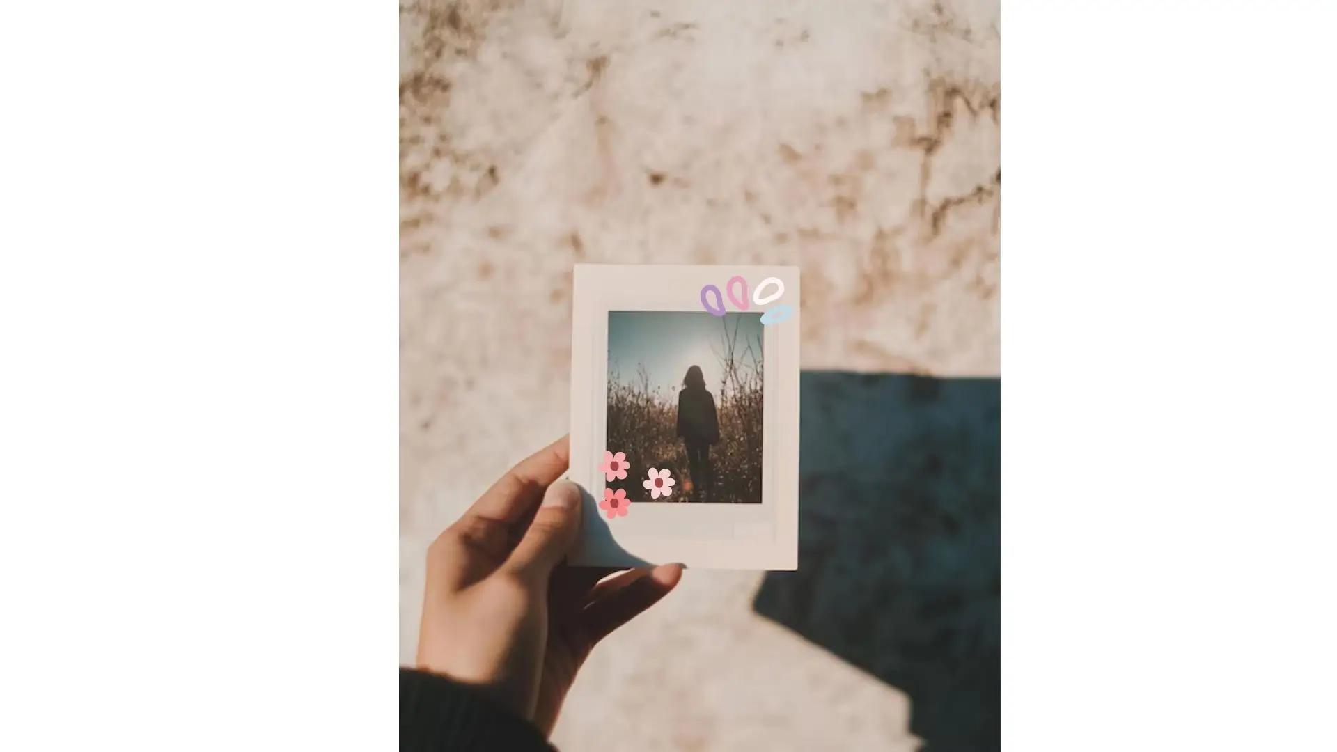 A person proudly displays a photo featuring a vibrant flower, showcasing their appreciation for nature's beauty.