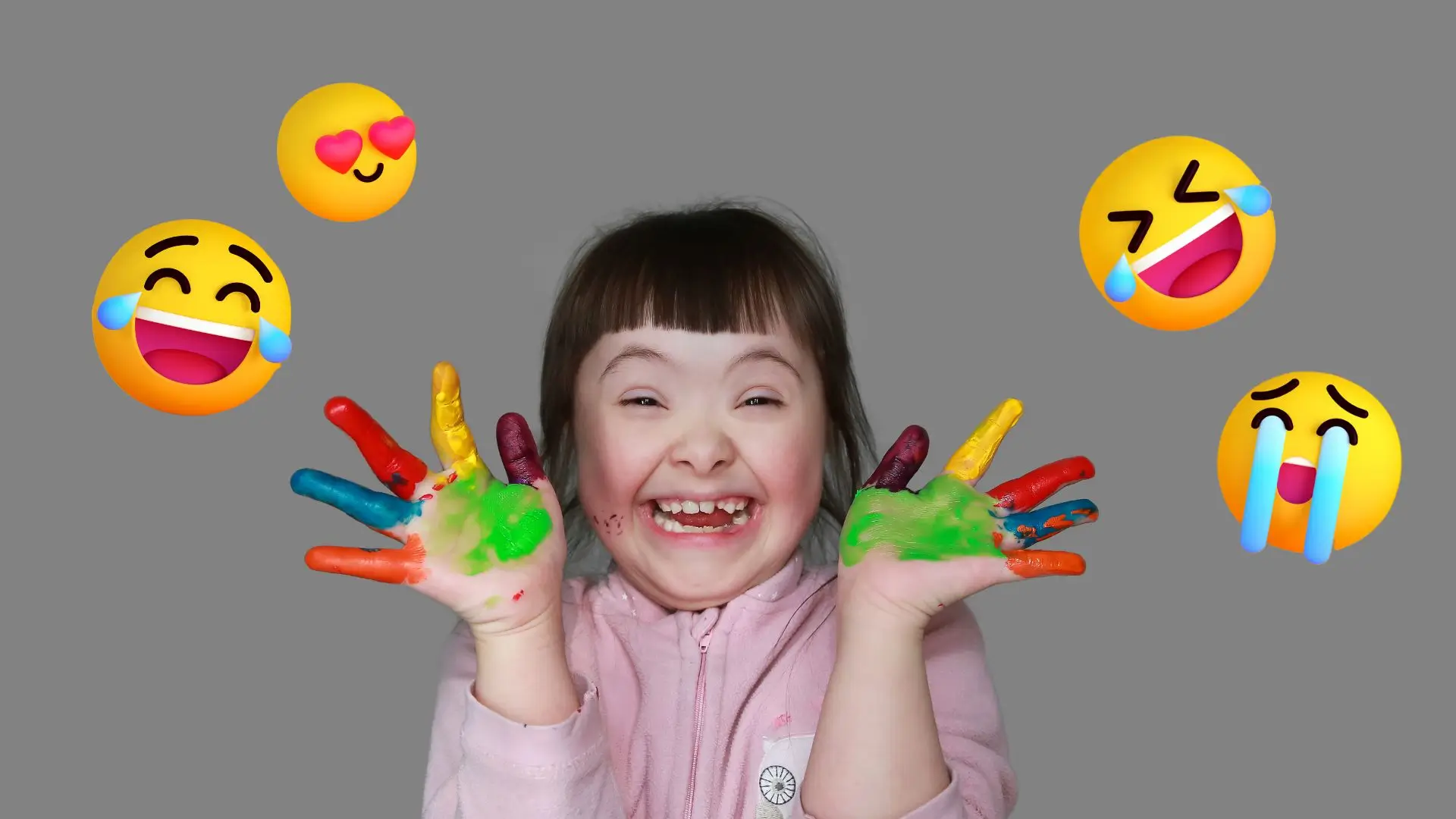 A joyful little girl smiles brightly with her hands raised high in the air, expressing pure happiness and excitement.